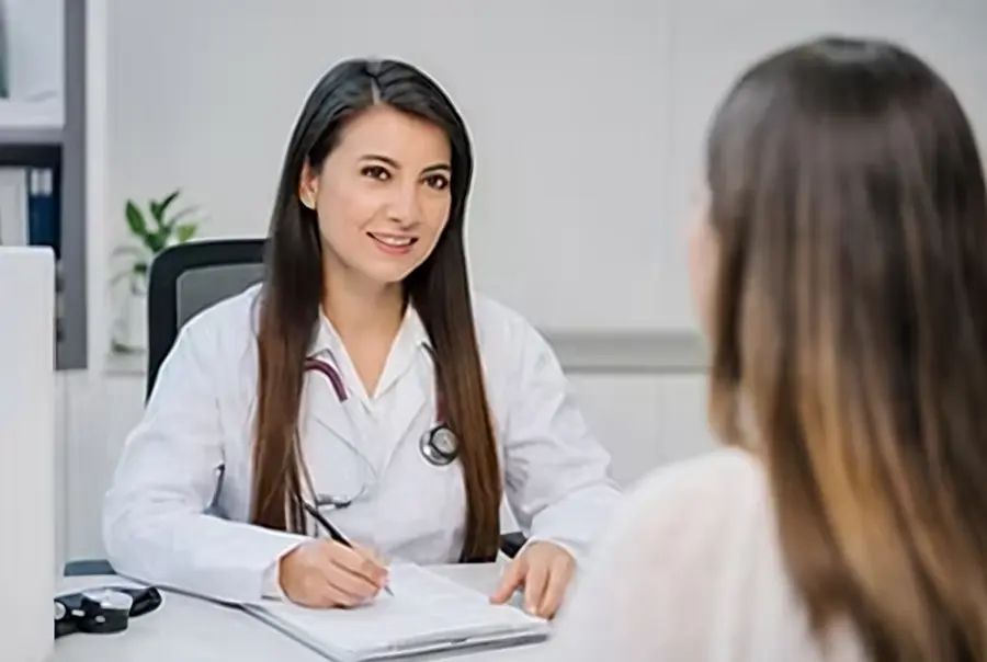 Médica internista en consulta con una paciente